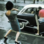 Femme glissant sur trottoir mouillé à côté d'une voiture