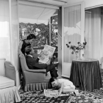 Famille lisant des journaux dans le salon