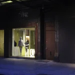 Vitrine de magasin avec mannequins sur rue sombre