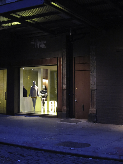 AKG1571204.webp Vitrine de magasin avec mannequins sur rue sombre – Image 1