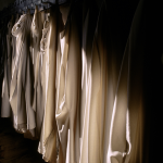 Robes accrochées dans une rangée de cintres en bois