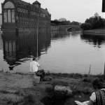 Pêche au bord du canal devant un bâtiment historique