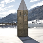 Clocher enneigé de l'église partiellement submergée dans le lac de Resia