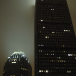 Gratte-ciel illuminés la nuit sous un ciel brumeux