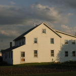 Maison de campagne blanche sous un ciel nuageux
