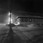 Maison en bois sous la neige en pleine nuit