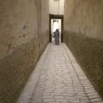 Personne marchant dans une ruelle étroite en pierre