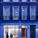 Façade de Broadbent House avec passants le soir