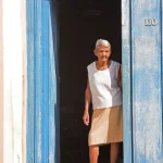 Femme âgée devant une porte bleue