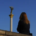 Femme regardant la colonne de l'Indépendance.