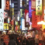 Rue commerçante animée avec enseignes lumineuses en Asie