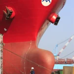 Ingénieur inspectant la proue d'un grand navire rouge