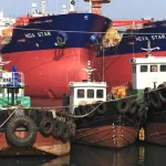 Bateaux de charge alignés dans un port industriel