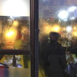 Scène de rue à travers la vitrine d'un restaurant asiatique.