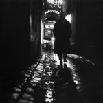 Homme marchant dans une ruelle éclairée la nuit