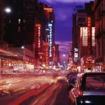 Rue animée la nuit avec néons et circulation