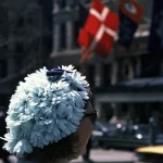 Femme avec chapeau de fleurs blanches dans une rue urbaine