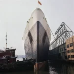 Paquebot accosté au port avec bateau-remorqueur