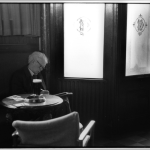 Homme âgé assis dans un café en train de lire