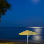 Plage de nuit avec parasol et chaise longue