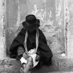 Homme assis contre un mur, pieds nus