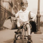 Garçon souriant en tricycle avec paniers dans une rue