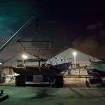 Chantier naval nocturne avec bateaux et grues