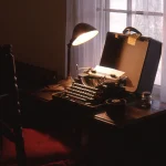 Machine à écrire vintage sous lampe de bureau près de fenêtre