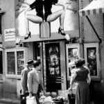 Devanture d'un théâtre avec passants et affiche de spectacle