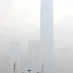 Bateau coloré devant des gratte-ciels dans un jour brumeux