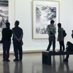 Visiteurs dans une galerie d'art admirant des paysages en noir et blanc