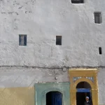 Vieille Bâtisse au Mur Blanc et Homme en Robe Traditionnelle