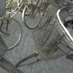 Vélos avec paniers stationnés sur un trottoir pavé