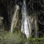 Cascade de printemps à travers les arbres nus