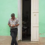 Homme se tenant devant une porte verte