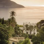 Vue sur la Méditerranée avec architecture et palmiers au coucher du soleil