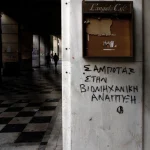 Graffitis sur un Mur avec Café Fermé et Personnes Marchant dans la Rue