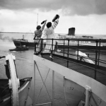 Deux femmes saluant un navire depuis le pont d'un bateau