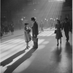 Scène de gare historique avec passants sous rayons de lumière