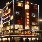 Bâtiment illuminé la nuit avec des enseignes lumineuses HO et WAR-ENHAUS