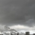 Usine industrielle sous un ciel sombre et nuageux