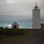 Phare au coucher du soleil avec petite maison
