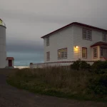 Phare et maison de gardien sur une côte au crépuscule