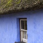 Fenêtre et Mur Bleu d'une Maison Traditionnelle avec un Toit de Chaume
