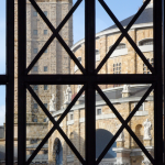 Vue du bâtiment historique à travers une fenêtre en métal