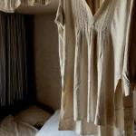 Tunique blanche suspendue près d'un lit