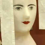 Tête de mannequin en céramique avec rideaux blancs