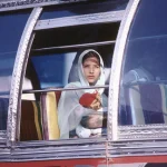 Mère et enfant regardant à travers la fenêtre d'un bus décoré