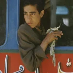 Jeune garçon regardant par la fenêtre d'un bus coloré