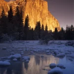 Montagne au coucher du soleil avec reflet sur lac gelé